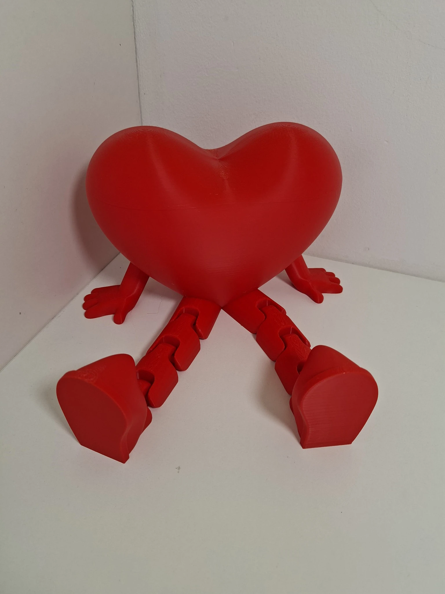 Crveno 3D ispisano srce s artikuliranim rukama i nogama