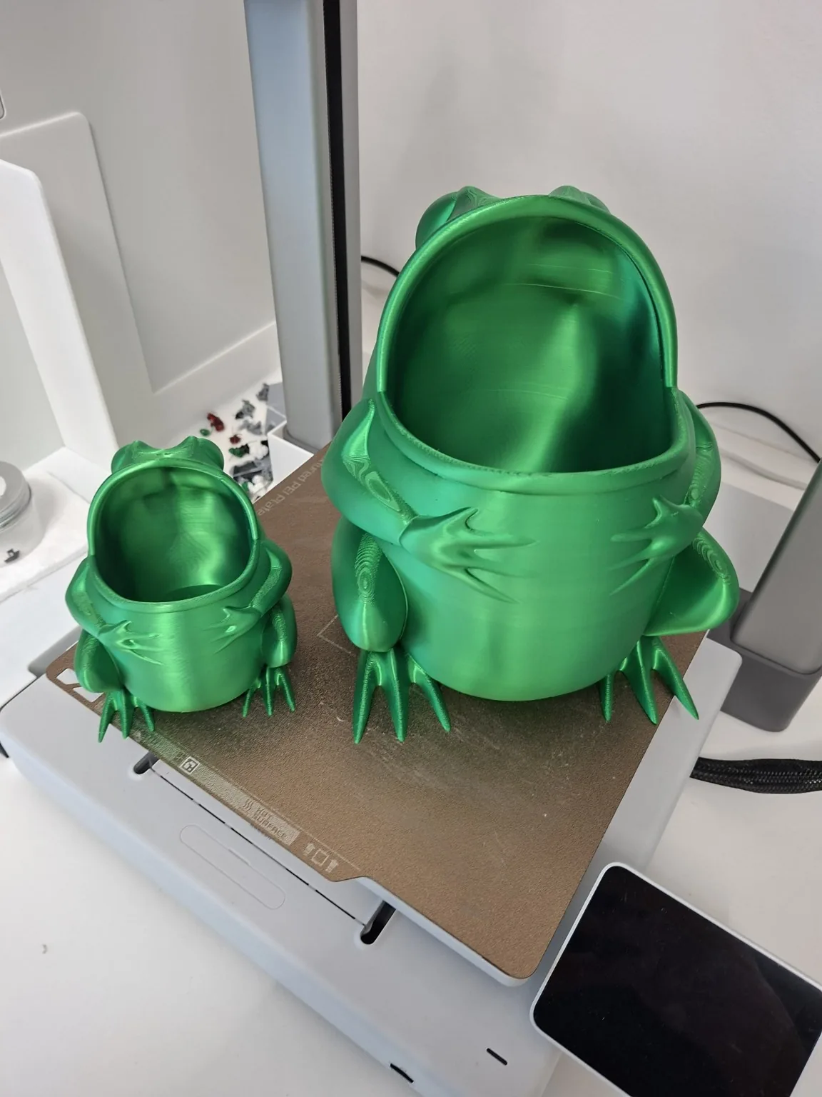 Dvije zelene 3D ispisane posude u obliku žabe na printeru